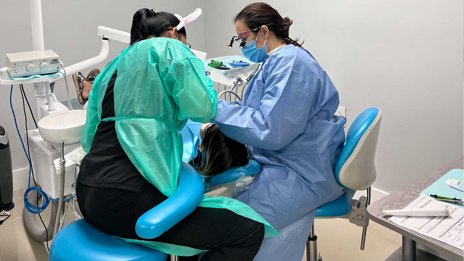 Orthodontics in Miami at Dental Blush Tamiami Orthodontics Miami at Dental Blush Tamiami with dentist and assistant caring for a patient in the dental chair