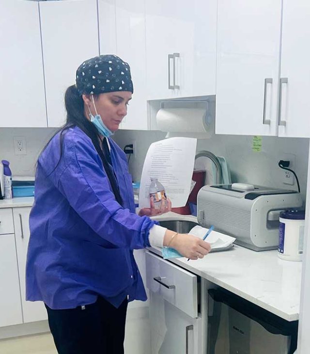 Katia Roman Chavez working in the sterilization area at Dental Blush